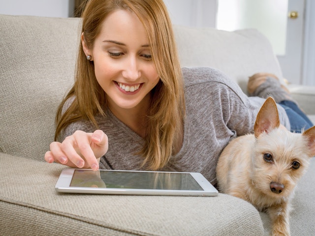 Flicka med hund och iPad